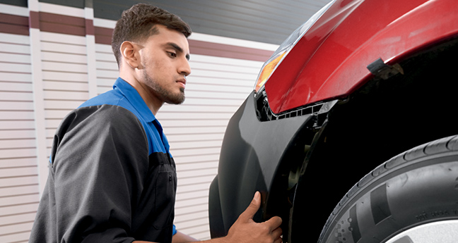 Mechanic checking front of car